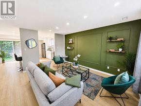 Kitchener multi-family for rent - A living room with a grey sofa and green chairs.
