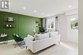 Kitchener multi-family for rent - A living room with a white couch and green accents.