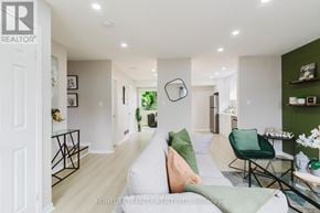Kitchener multi-family for rent - A living room with a white couch and a green chair.