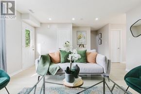 Kitchener multi-family for rent - A living room with a grey sofa, a coffee table, and a green armchair.