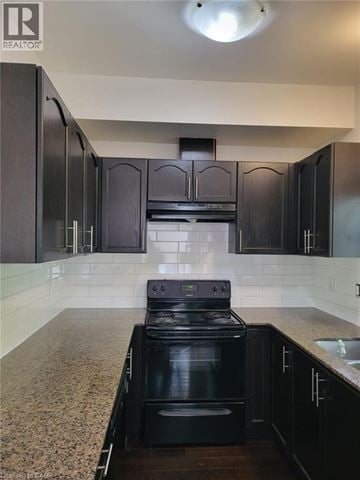 Kitchener townhouse for rent - A modern kitchen with black cabinets and a black stove top oven.