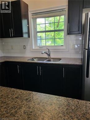 Kitchener townhouse for rent - A kitchen with black cabinets and a granite countertop.