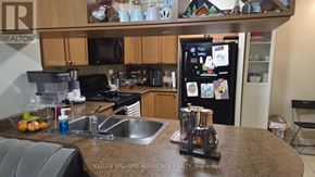 Mississauga (City Centre) condo for rent - A kitchen with a refrigerator, sink, and microwave.