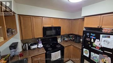 Mississauga (City Centre) condo for rent - A kitchen with a black stove top oven and a black microwave.
