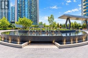 Toronto (Mimico) condo for rent - A fountain in the middle of a plaza with a building in the background.