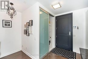 Toronto (Mimico) condo for rent - A hallway with a black door and a glass door leading to a laundry room.