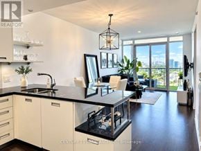 Toronto (Mimico) condo for rent - A modern kitchen with white cabinets and black countertops.