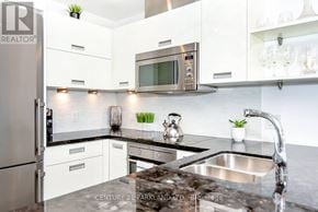 Toronto (Mimico) condo for rent - A modern kitchen with a stainless steel refrigerator and a microwave above the stove.