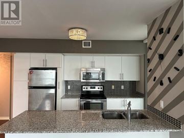 Toronto (Mimico) condo for rent - A modern kitchen with granite countertops and stainless steel appliances.