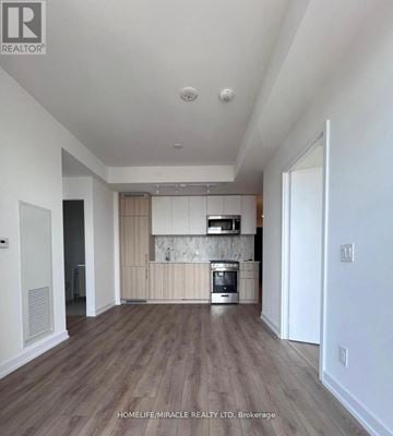 Toronto (Annex) condo for rent - A modern kitchen with wooden floors and white walls.