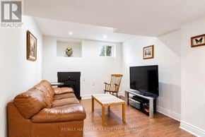 Richmond Hill (Jefferson) apartment for rent - A living room with a brown leather couch, a wooden chair, and a flat screen TV.