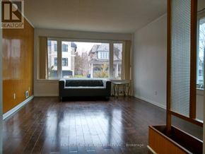 Toronto (Banbury-Don Mills) apartment for rent - A living room with a couch and a table in front of a large window.