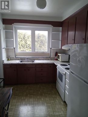 Toronto (Banbury-Don Mills) apartment for rent - A kitchen with white appliances and brown cabinets.