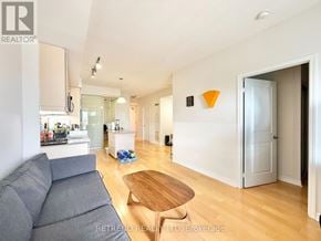Toronto (Bayview Village) condo for rent - A living room with a grey couch and a wooden table.