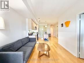 Toronto (Bayview Village) condo for rent - A living room with a grey couch and a wooden coffee table.