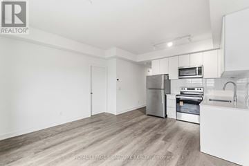 St. Catharines (E. Chester) townhouse for rent - A kitchen with white cabinets and a stainless steel refrigerator.