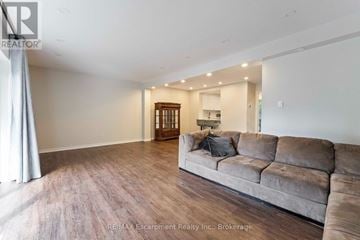 Mississauga (Clarkson) townhouse for rent - A living room with a grey couch and wooden floors.