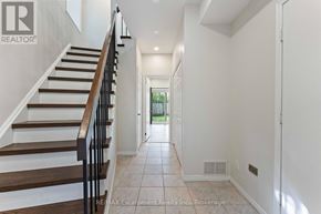 Mississauga (Clarkson) townhouse for rent - A hallway with a staircase and a door at the end.