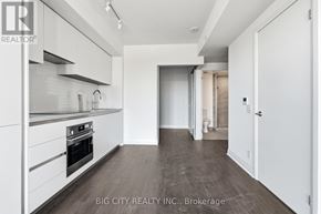 Toronto (Thorncliffe Park) condo for rent - A modern kitchen with white cabinets and a wooden floor.