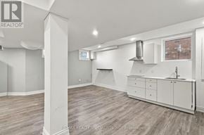 Milton (Cl Clarke) apartment for rent - A spacious kitchen with white cabinets and a brick wall in the background.