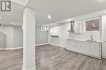 Milton (Cl Clarke) apartment for rent - A spacious kitchen with white cabinets and a brick wall in the background.