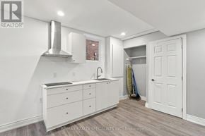 Milton (Cl Clarke) apartment for rent - A white kitchen with a sink and a broom in the corner.