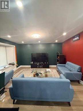 Ajax (South East) apartment for rent - A living room with a blue couch and a flat screen TV.