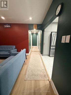 Ajax (South East) apartment for rent - A hallway with a blue couch and a clock on the wall.