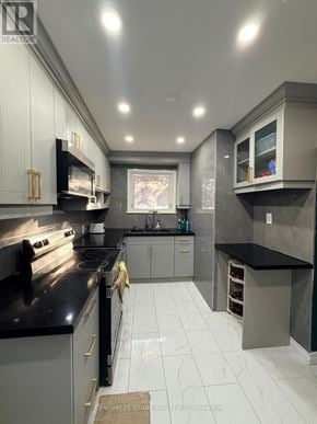 Ajax (South East) apartment for rent - A modern kitchen with black countertops and white cabinets.