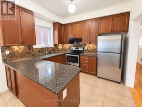 Whitby (Williamsburg) apartment for rent - A kitchen with granite countertops and wooden cabinets.