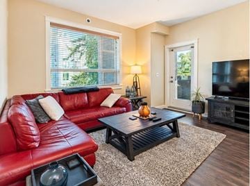 Surrey apartment for rent - A living room with a red leather couch and a black coffee table.