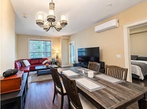 Surrey apartment for rent - A well-lit dining room with a wooden table and chairs.