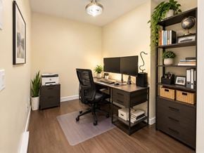 Surrey apartment for rent - A home office with a desk, chair, and shelving unit.