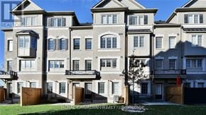 Oshawa (Windfields) townhouse for rent - A large, multi-story residential building with balconies and multiple windows.