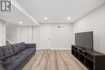 Mississauga (Churchill Meadows) townhouse for rent - A living room with a grey couch and a television on a stand.