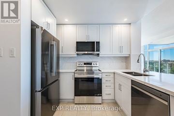 Brampton (Downtown Brampton) condo for rent - A modern kitchen with white cabinets and stainless steel appliances.