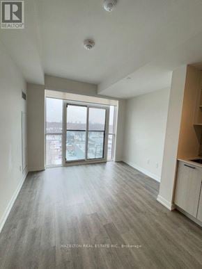 Toronto (Junction Area) condo for rent - A room with a large window and wooden flooring.
