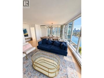 Vancouver apartment for rent - A blue sofa sits in a living room with a view of the city.