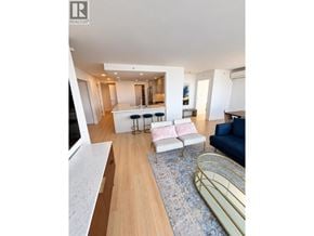 Vancouver apartment for rent - A living room with a white sofa and a blue rug.