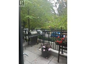 Vancouver apartment for rent - A patio with a table and chairs and a planter with flowers.