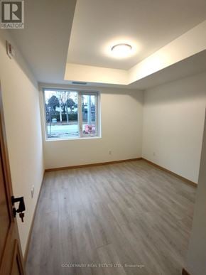 Toronto (L'amoreaux) townhouse for rent - A room with a window showing a view of a parking lot and trees.