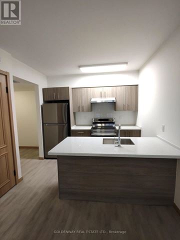Toronto (L'amoreaux) townhouse for rent - A kitchen with a white counter top and brown cabinets.