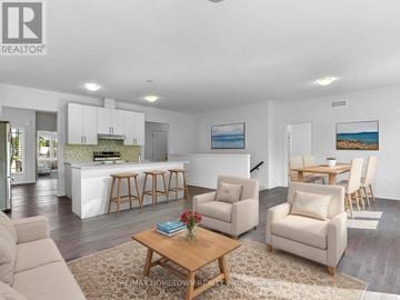 Brockville apartment for rent - A living room with a white couch, a coffee table, and a painting of a beach scene on the wall.