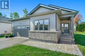 Brockville apartment for rent - A house with a grey siding and a stone wall is for sale.