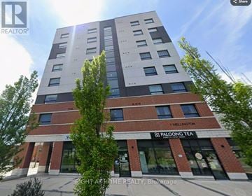 Brantford condo for rent - A tall building with a sign that says "PALGONG TEA" on the front.