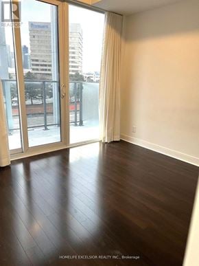 Mississauga (City Centre) condo for rent - A room with a view of the city through a sliding glass door.