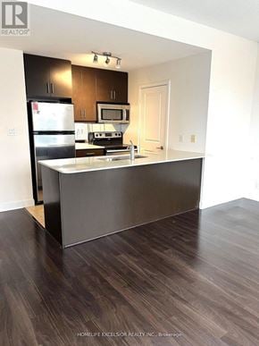 Mississauga (City Centre) condo for rent - A kitchen with dark wood floors and white walls.