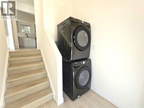 Cambridge apartment for rent - A black washing machine and dryer stacked on top of each other in a room.