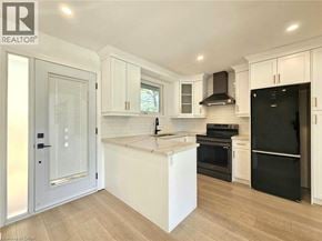 Cambridge apartment for rent - A modern kitchen with white cabinets and a black fridge.