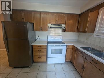 Cambridge apartment for rent - A kitchen with wooden cabinets and a black refrigerator.